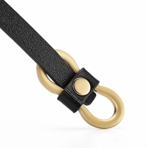 Detail of black lychee texture leather belt with a golden horseshoe U-shaped buckle