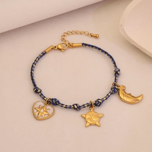 Détail du bracelet tissé avec pendentifs soleil lune coeur dorés et fil bleu doré
