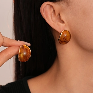 Retro amber resin stud earrings with gold metal rim featuring a marbled round design