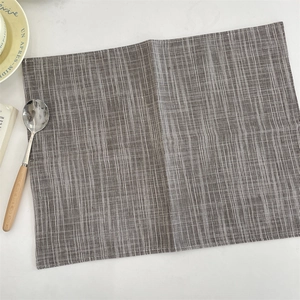 Detail view of dark grey and white striped linen placemat with premium stitching edges