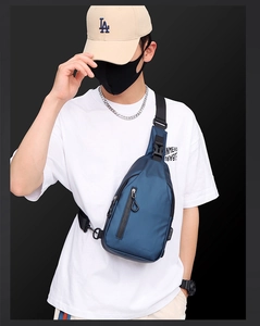Detail of navy blue waterproof nylon chest bag with adjustable strap and zip pockets