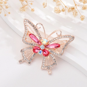 Detailed view of butterfly brooch featuring gold plating with pink and rainbow gemstones