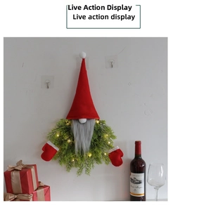 Close-up of lighted Christmas gnome wreath with pine needles and red gloves on wall