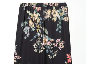 Detail of elastic waist on black floral print trousers with vibrant botanical pattern