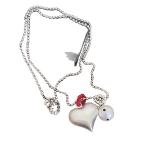 Silver bead chain necklace with brushed heart and red crystal accents on white background