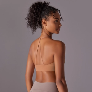 Detail view of crisscross strappy back on a nude-toned nylon yoga sports bra