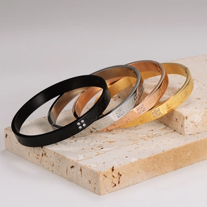 Set of stainless steel bangles with Greek key pattern and diamonds on stone pedestals