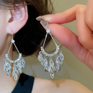 Macro shot of silver tassel drop earrings featuring teardrop and marquise cut zircons
