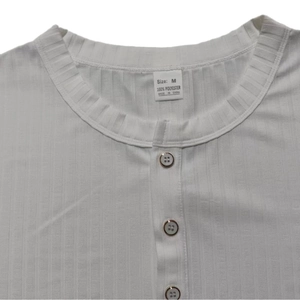 Detailed view of the V-neckline and button placket on a white ribbed knit Henley shirt