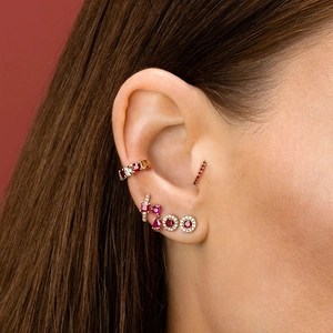 Close-up of model wearing rose gold earrings with ruby stones and micro-pave crystals