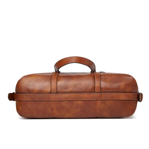 Detail view showing the natural leather texture and structure of the brown cylindrical tote bag