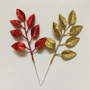Close-up of glittered artificial Christmas leaves in red and gold for DIY wreath making