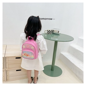 Rear view of a pink mermaid PU backpack on a little girl with shell and starfish details