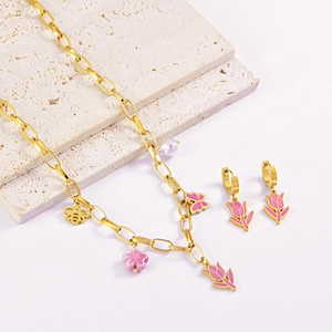 Gold necklace and earring set with pink tulip, butterfly pendants on a stone base