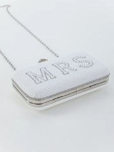 Detail of white pearl beaded clutch featuring MRS lettering and silver metal chain strap