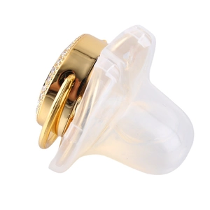 Close-up of golden baby pacifier with luxury rhinestones and transparent silicone nipple