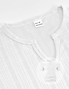 Close-up of white waffle texture polyester fabric and V-neck detail of men's short sleeve T-shirt