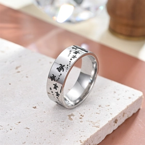 Detailed macro view of engraved black turtle pattern on silver stainless steel ring
