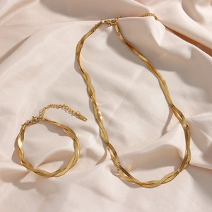 Dettaglio del set di gioielli catena a spina di pesce placcato oro 18K su seta