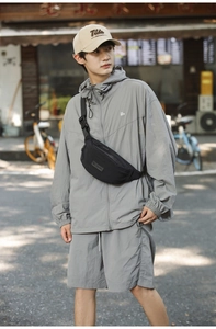 Detail of multi-functional black waist bag and casual dark grey hooded sports jacket set