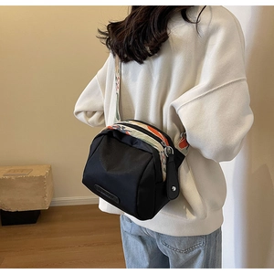 Detail view of black oxford crossbody bag with colorful patterned wide shoulder strap