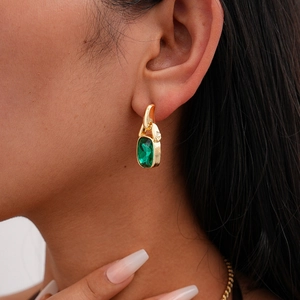 Dettaglio degli orecchini vintage in oro con una grande pietra verde taglio smeraldo