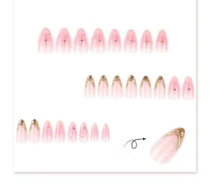 Detail view of pink gradient press-on nails with 3D gold embossed texture and rhinestones
