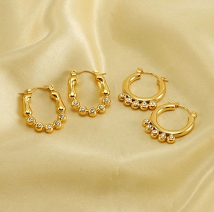 Vue détaillée de boucles d'oreilles dorées avec cristaux de zircon sur soie