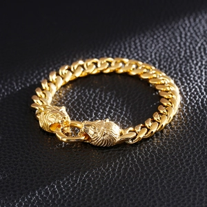 Détail du bracelet gourmette doré avec deux têtes de lion sur un fond de cuir noir
