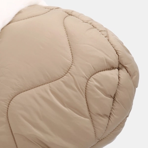 Macro shot of khaki quilted fabric with wave stitching and soft white faux fur detail