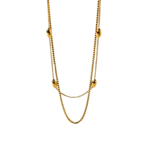 Minimalist multi-layer gold necklace featuring delicate box chains and oval bead accents