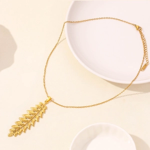 Detailed close-up of a gold leaf pendant necklace with fine lobster clasp and extender
