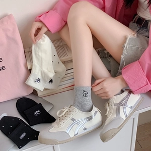 Breathable combed cotton socks with cute embroidery in various colors on a white surface