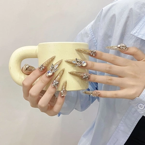 Luxurious handmade champagne gold stiletto press-on nails with 3D rhinestones and butterfly chains