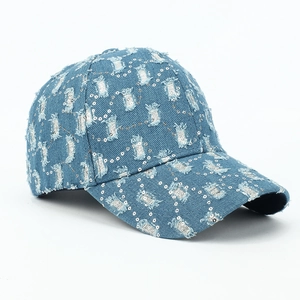 Détail d'une casquette de baseball en jean bleu délavé avec ornements de paillettes argentées