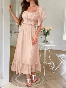 Détails de la robe d'été rose clair à épaules dénudées avec ourlet à volants légers