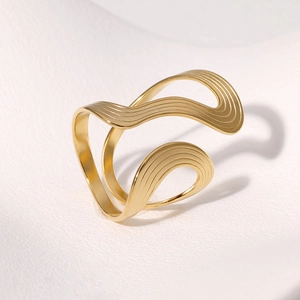 Macro detail of golden wave-textured ring showing linear parallel engraved patterns