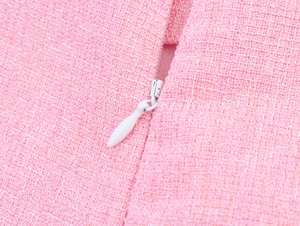 Makroaufnahme des verdeckten Reißverschlusses auf rosa Tweed-Stoff mit Webstruktur