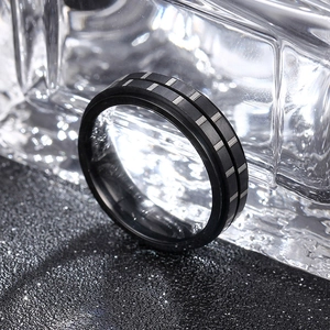 Macro shot of a 6mm black rotating titanium steel ring on a reflective ice background