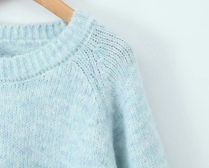 Close-up of the light blue mohair knit sweater neckline and soft texture details