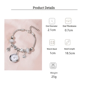 Detail showing the silver charm watch with crown pendant and tree of life on satin