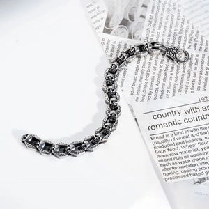 Macro detail of men's gothic skull chain bracelet in oxidized stainless steel finish