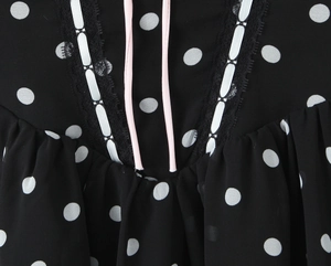 Detail von schwarzem Polka-Dot-Stoff mit feiner Spitze und rosa Kordelzug-Dekoration
