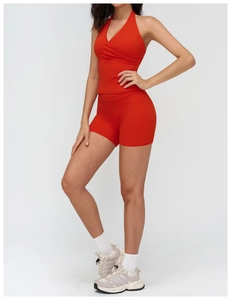 Detail of red halter yoga top and high waist shorts set in elastic performance fabric