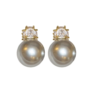 Elegant gold earrings featuring a gray pearl and clear zircon crystal on white background