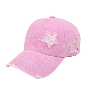 Dettaglio del berretto rosa con stella di paillettes e tesa con effetto consumato