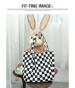 Detail of classic black and white checkered canvas tote bag with matching strap