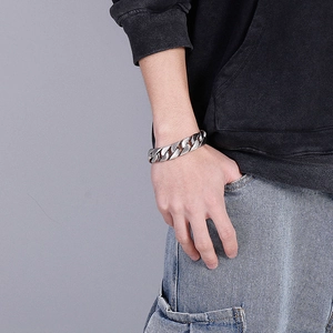 Silbernes Panzerarmband am männlichen Model mit schwarzem Hoodie und hellblauer Jeans