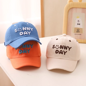 Detail of cotton canvas kids caps with Sunny Day embroidery in blue, orange and beige