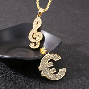 Close-up of hip hop gold-plated treble clef and euro symbol pendants with pave-set crystals